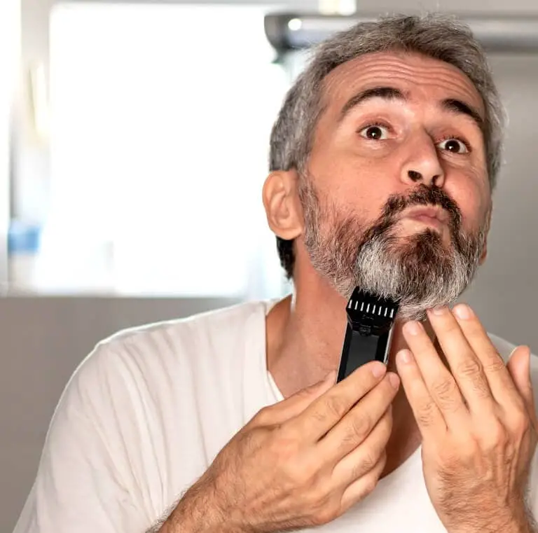 Man som trimmar sitt skägg med en skäggtrimmer